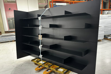 Bibliothèque métallique sur mesure eloxée noire poudrée, fabriquée en atelier et prête pour transport après finition.